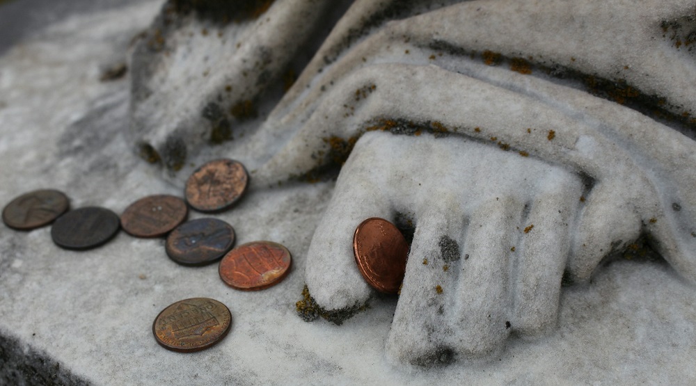 coins pennies at statue feet photo by Haley Owens via Unsplash