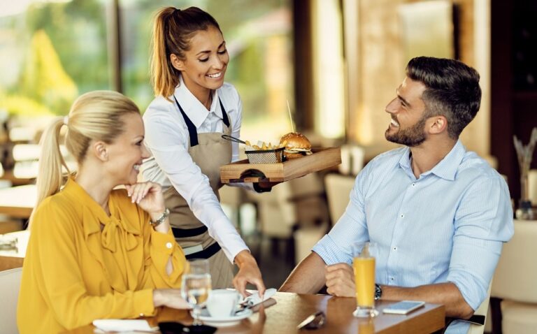 Server delivering food to diners.