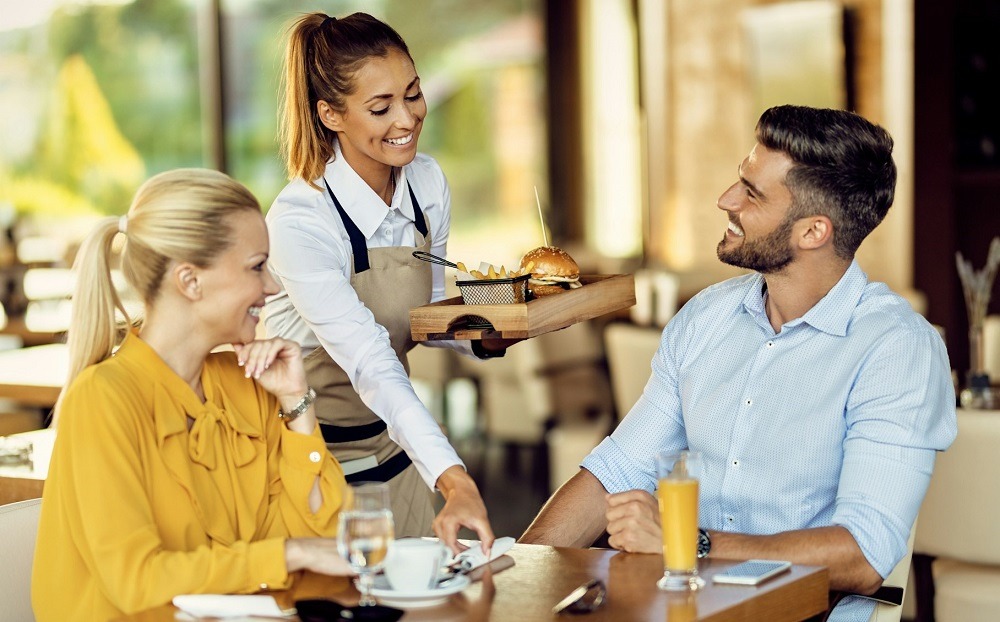 Server delivering food to diners.