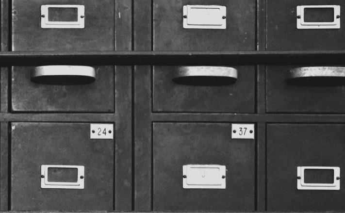 Metal filing cabinets with numbered drawers labeled 24 and 37. The image conveys organization and archival methods relevant to document management.