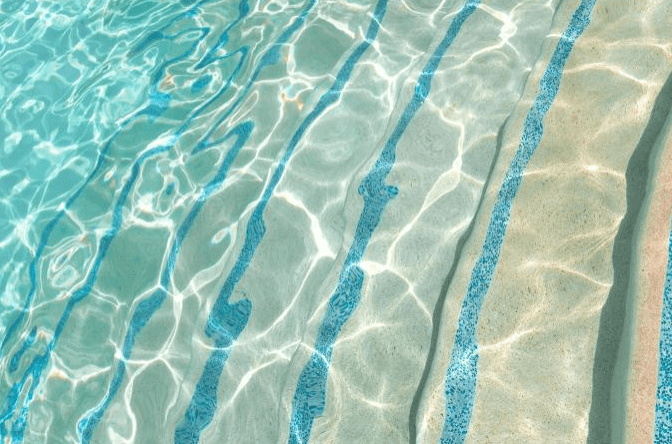 Rippling turquoise pool water reveals smooth sandy pool steps, highlighting the refreshing aquatic environment. Ideal for a relaxation or leisure setting.
