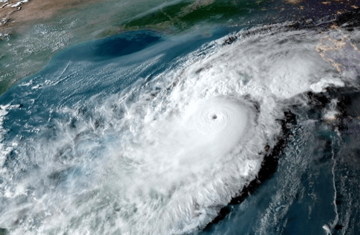 Satellite image of a powerful hurricane swirling over the ocean, showcasing its eye and surrounding cloud formations, highlighting its intensity and potential impact.