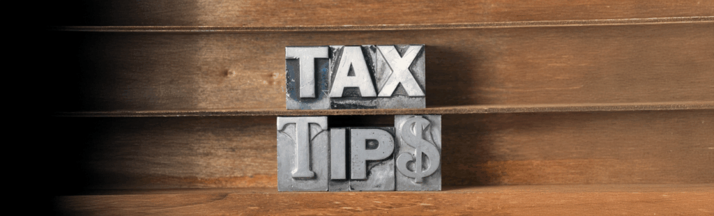 "Bold metal letterpress blocks spelling 'TAX TIPS' on wooden shelves, symbolizing financial advice and tax preparation guidance."