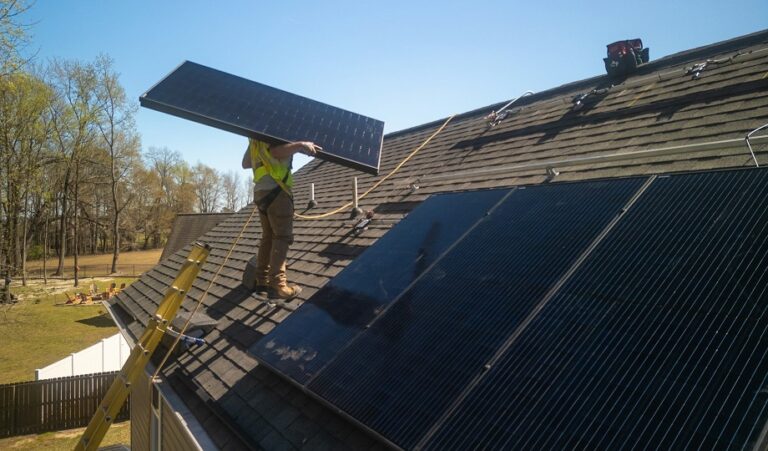 Roofer carrying a solar panel to install. Getty Images for Unsplash+